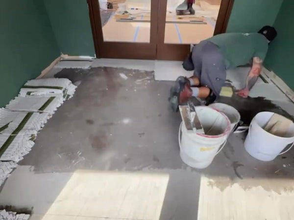 Numbered mosaic mesh sheets laid out at a shop entrance before installation
