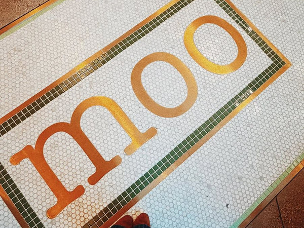 Colorful moo lettering mosaic at a restaurant entrance