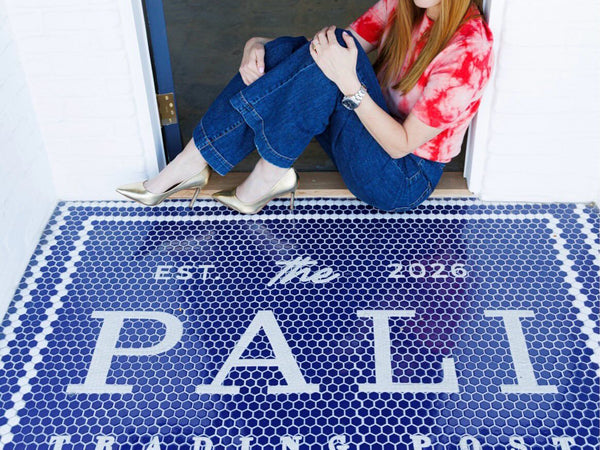 Shop owner standing on her blue custom logo mosaic entrance