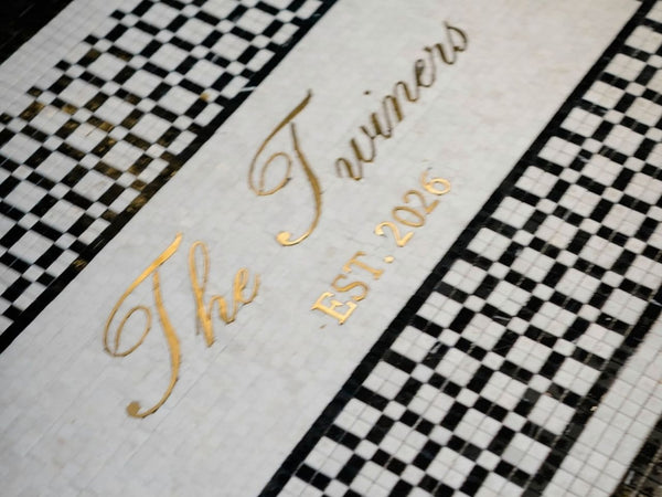 Entryway mosaic with gold script lettering and checkerboard border