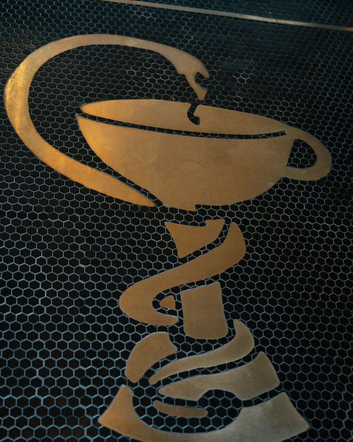 Gold cup logo on black hexagon, restaurant logo mosaic by Mosaic Lettering, photographed at our studio before installation