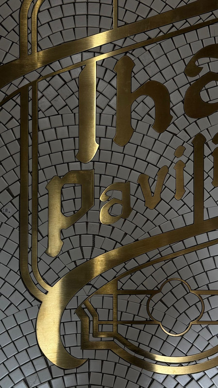 Gold metal lettering detail close-up, gold metal lettering mosaic by Mosaic Lettering, photographed at our studio before installation