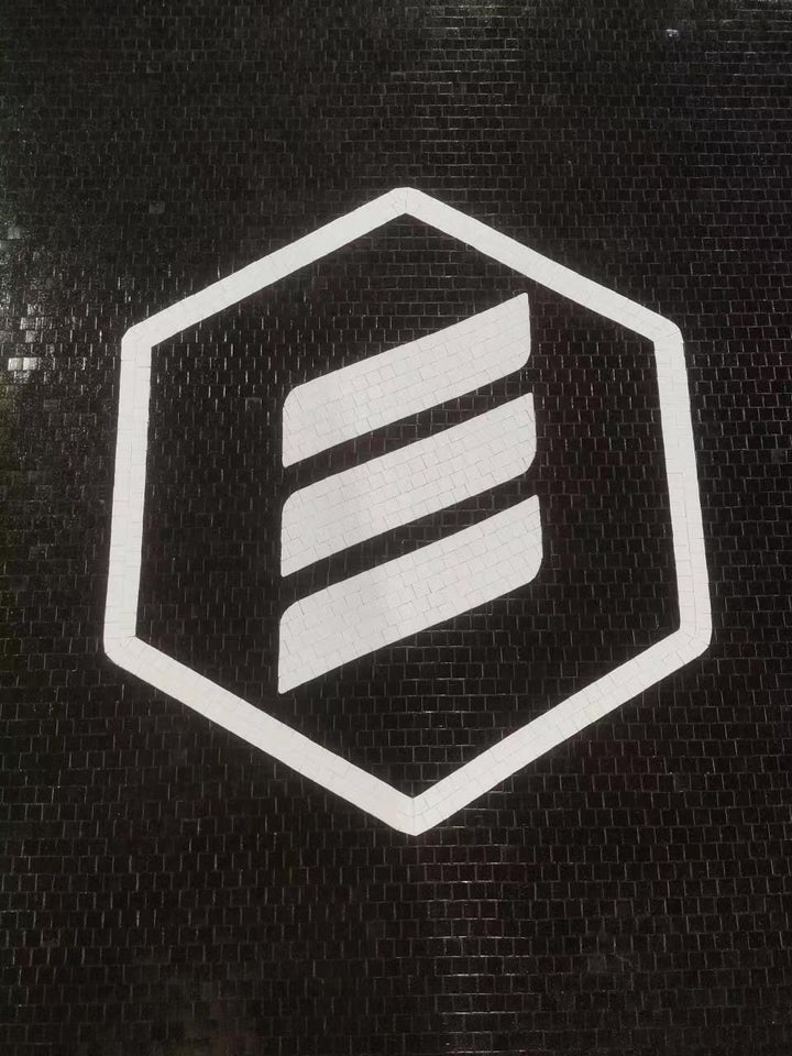 Hexagon logo on black mosaic, business logo mosaic by Mosaic Lettering, photographed at our studio before installation