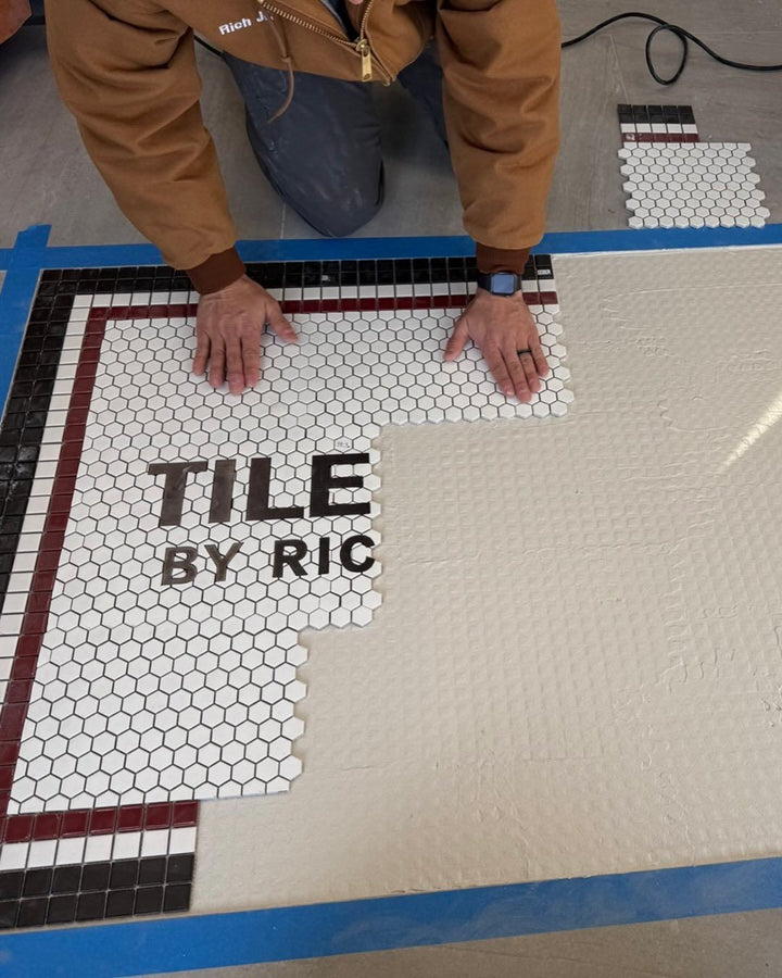 Installer placing mesh sheets, business logo mosaic by Mosaic Lettering, photographed at our studio before installation