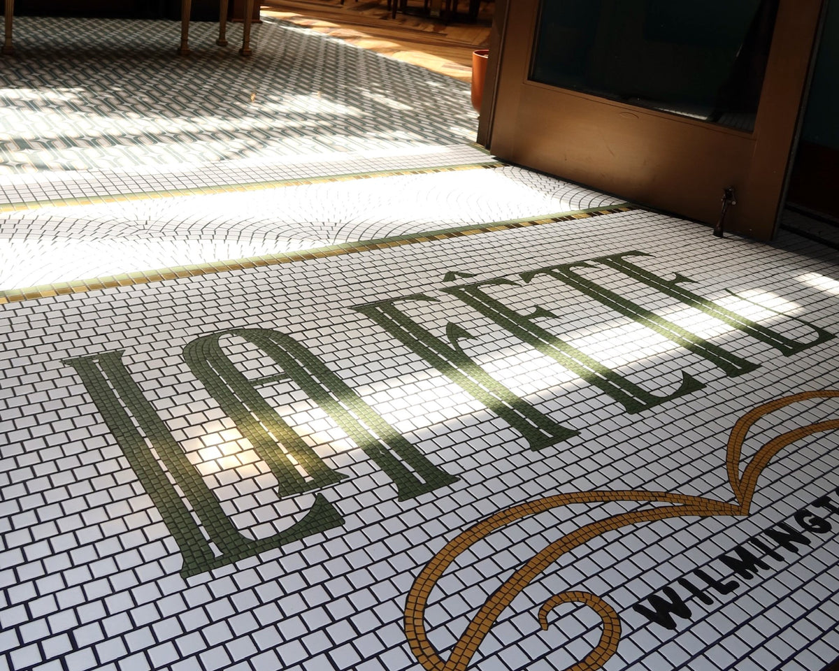 La Fete green and gold tile lettering mosaic at a restaurant entrance in Wilmington