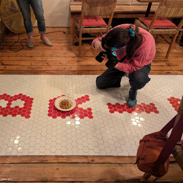 Laying a hexagon tile mosaic on site, restaurant logo mosaic by Mosaic Lettering