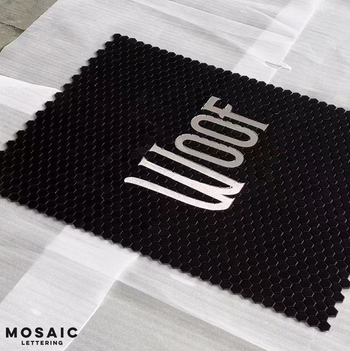 Woof black hexagon pet shop mosaic, business logo mosaic by Mosaic Lettering, photographed at our studio before installation